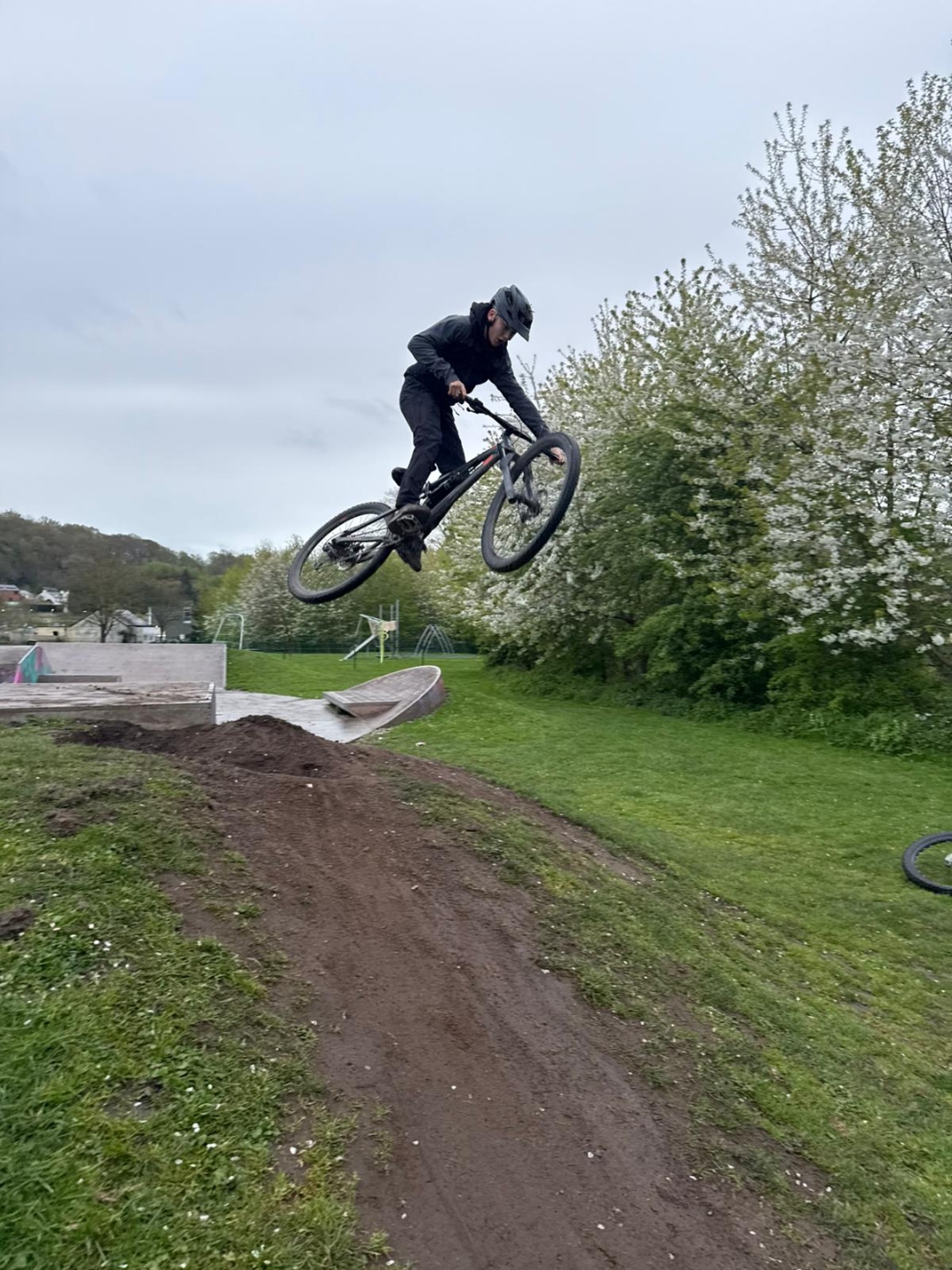 Front three-quarter view of Alfie's mountain bike by a bridge.